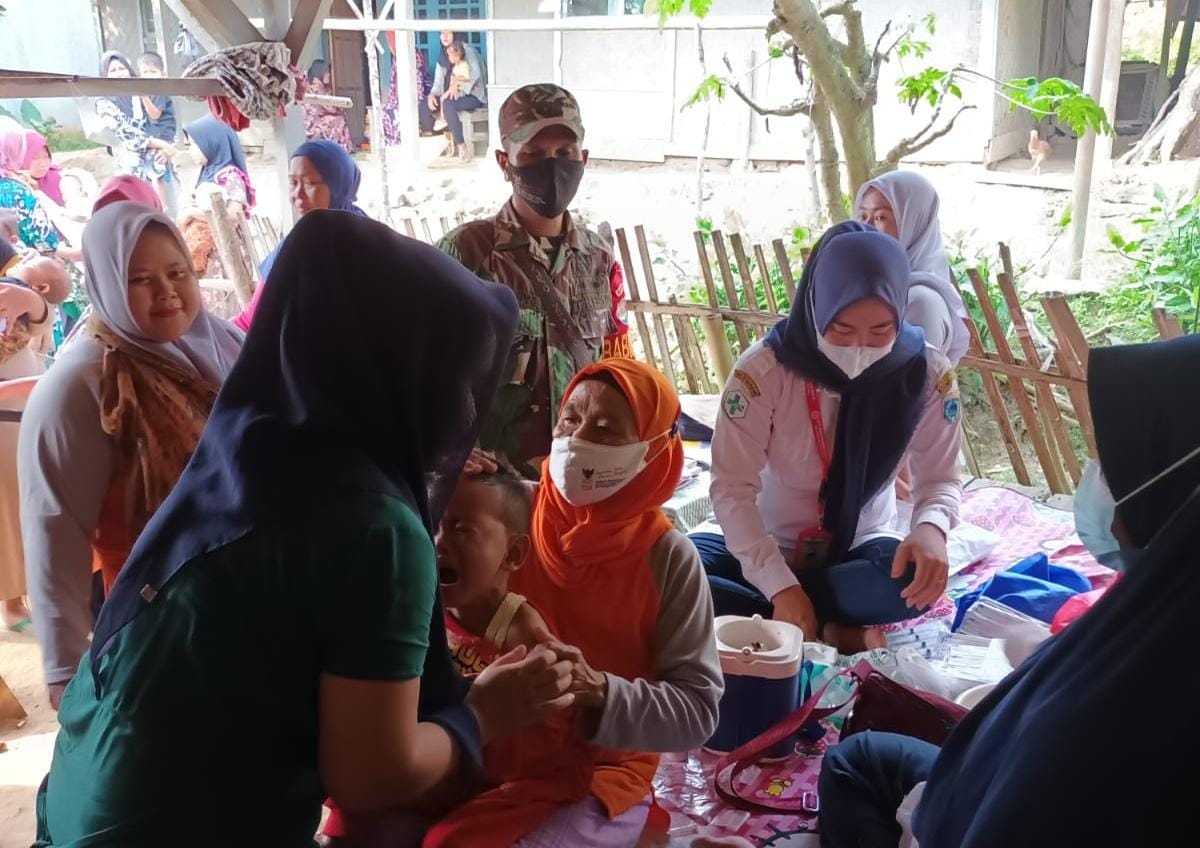 Serda Widagyo Babinsa Koramil 0111/Pagelaran Bantu Pelaksaan Bulan Imunisasi Anak Nasional (BIAN) Di Desa Binaan