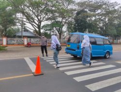 Personil Polsek Warunggunung Polres Lebak Membantu menyebrangkan anak Sekolah