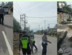 Bripka Ismanto Bersihkan Genangan Air Di Jalan.