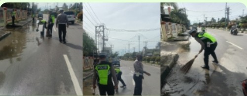 Bripka Ismanto Bersihkan Genangan Air Di Jalan.