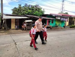 Polisi Sahabat Anak, Bhabinkamtibmas Desa Pakkatto Bantu Menyebrangkan Siswa-Siswi SD