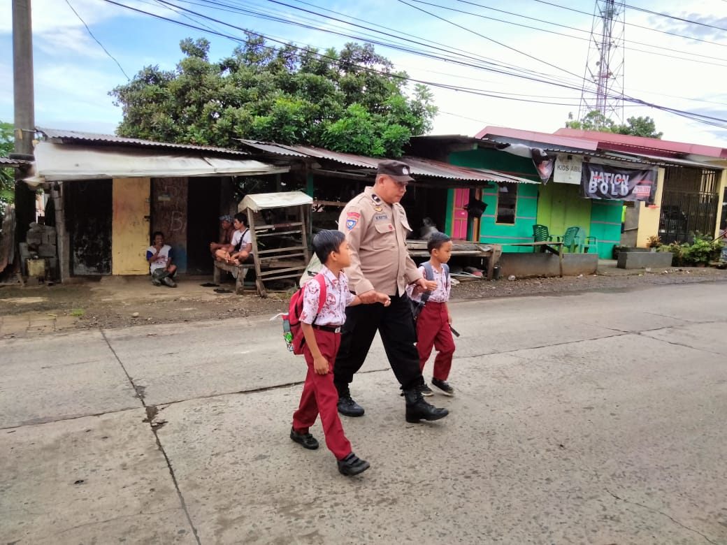 Polisi Sahabat Anak, Bhabinkamtibmas Desa Pakkatto Bantu Menyebrangkan Siswa-Siswi SD