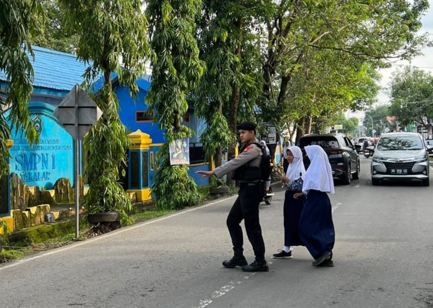 Unit Samapta Polres Takalar Bantu Pelajar Menyeberang Jalan