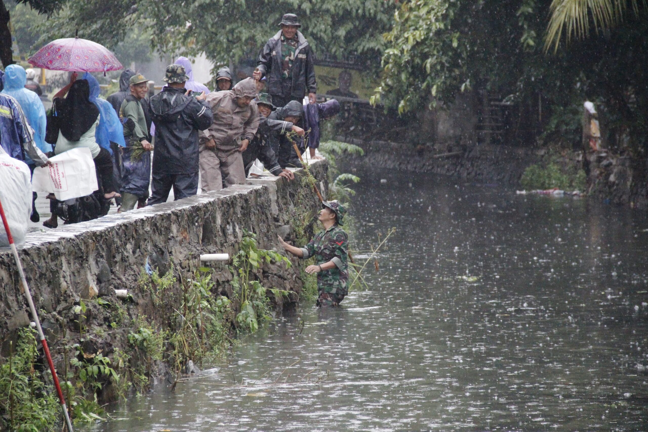 Hujan Gerimis Tak Menghalangi Prajurit Koramil 01/Kranji Untuk Melaksanakan Karya Bakti TNI Bersihkan Kali Perumnas Dan Penanaman Pohon Produktif