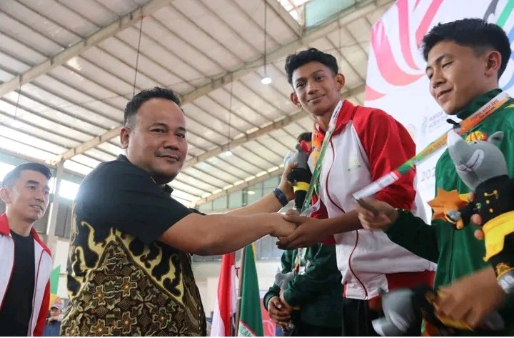 Pj. Sekda Aceh Timur Mengalungkan Medali Emas Cabor Pencak Silat