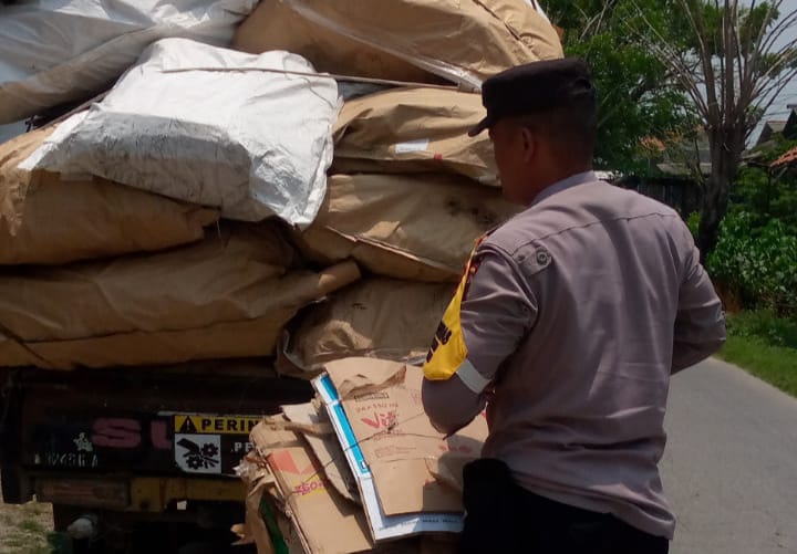 Bhabinkamtibmas Polsek Pebayuran Membantu Membereskan Barang Muatan Pengendara Mobil Pick Up Yang Terjatuh